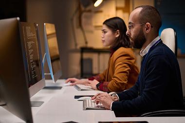 People looking at computer screens in office