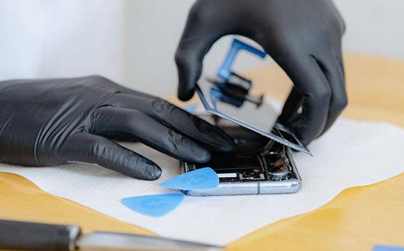 Technician removing back of phone for repairs